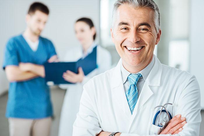 A picture of a doctor posing for a picture in a patient ward